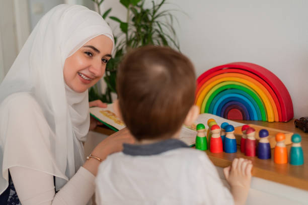 A Musllim teacher and preschool child playing together with colorful toys in the Montessori school classroom or kindergarten. . High quality photo